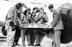 SHORT-SERVICE PILOTS studying the construction of the elevators of an aeroplane