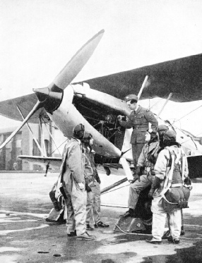 AN INSTRUCTOR EXPLAINING ENGINE DETAILS to a group of pupils at the Service flying training school at Sealand Aerodrome