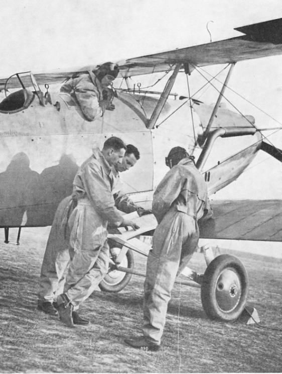 VOLUNTEER RESERVE PILOTS DISCUSSING DETAILS OF A FLIGHT before taking off in a Hawker Hart Trainer