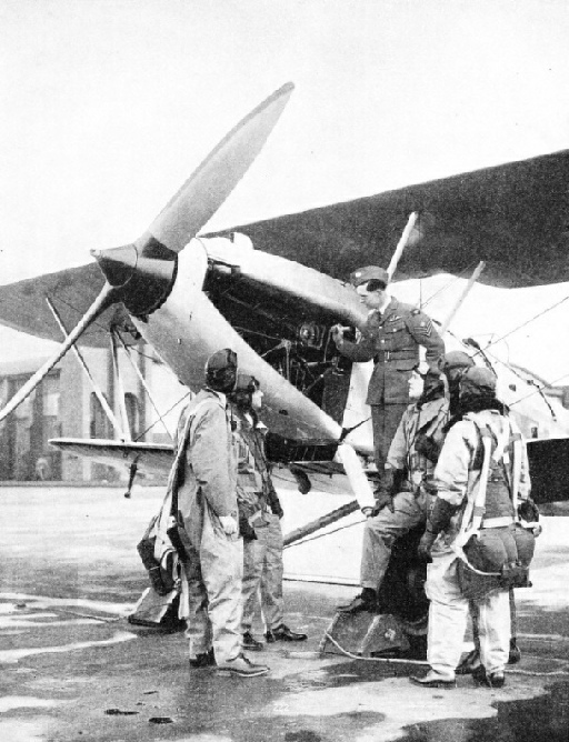 AN INSTRUCTOR EXPLAINING ENGINE DETAILS to a group of pupils at the Service flying training school at Sealand Aerodrome